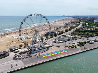 Légi felvétel a rimini óriáskerékről, az adriai tengerpartról és a színes Rimini feliratról az olaszországi tengerparton.